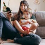 filmes infantis na Netflix - Mãe e filho pequeno assistindo Tv no sofá