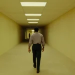 O ator Chiwetel Ejiofor anda em um corredor em cena em tom amarelo do filme Backrooms - Um Não-Lugar de 2026