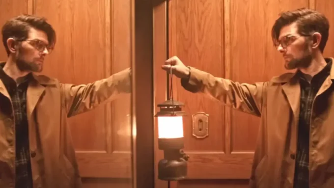 homem levanta luminária em cena do filme Hokum O Pesadelo da Bruxa de 2026 (1)