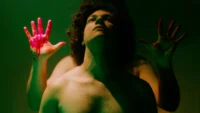 homem negro sem camisa com mãos atrás dele em cena do filme brasileiro Labirinto dos Garotos Perdidos de 2026
