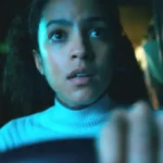 mulher dirige o carro assustada em cena do filme de terror Passageiro do Mal de 2026 (1)