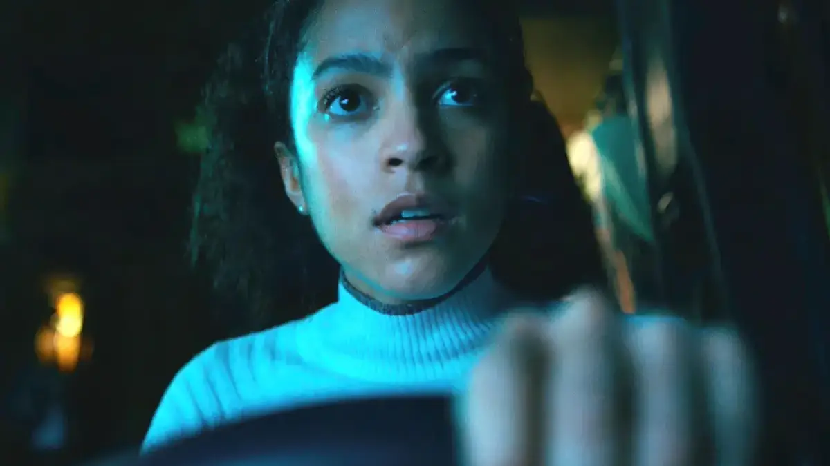 mulher dirige o carro assustada em cena do filme de terror Passageiro do Mal de 2026 (1)