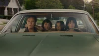 Anne Hathaway, Ewan McGregor, Maisy Stella e Christian Convery dentro de um carro em cena do filme O Fim da Rua, de 2026