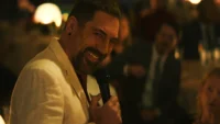 Javier Bardem sorrindo com um microfone na mão em cena da série Cabo do Medo de 2026 disponível no Apple TV