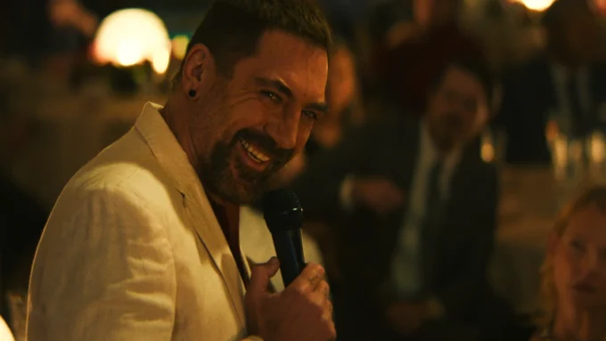 Javier Bardem sorrindo com um microfone na mão em cena da série Cabo do Medo de 2026 disponível no Apple TV